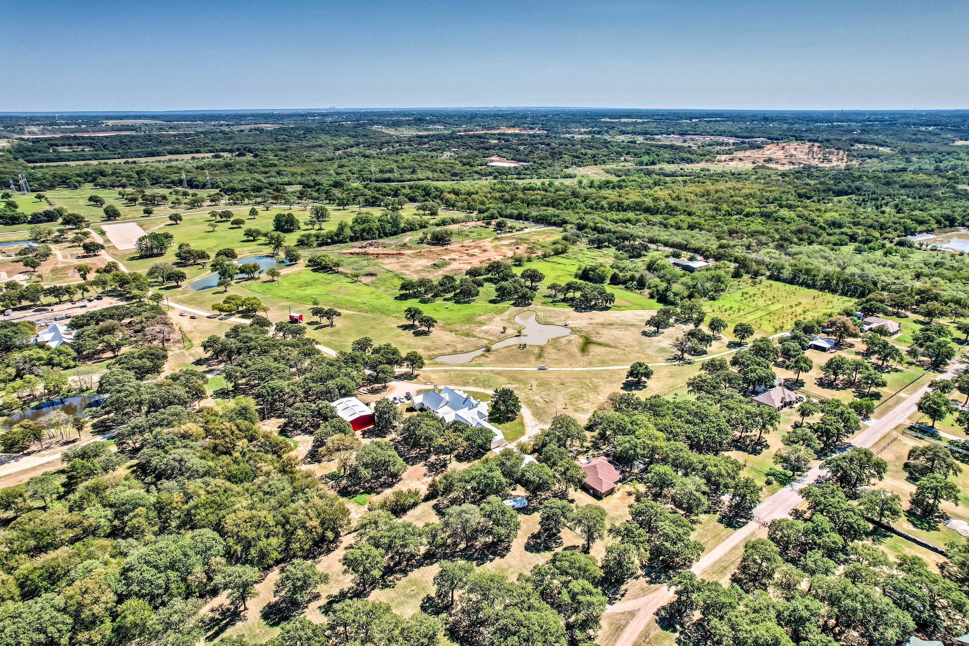 Vue aérienne d’un quartier résidentiel avec de nombreuses maisons, des rues et des espaces verts.