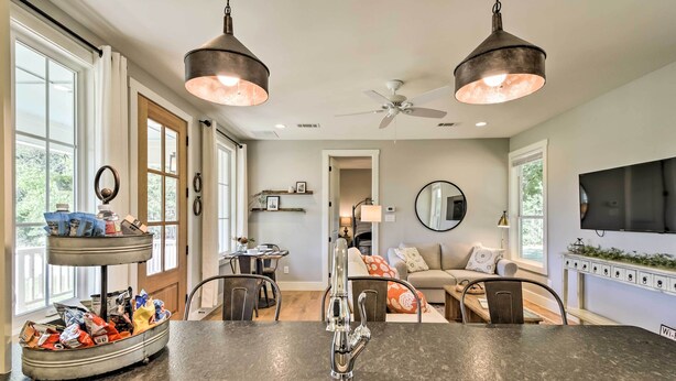 A kitchen with a double sink, two pendant lights, a ceiling fan, and a dining area with a table and chairs. - 12 Mi to Tcu: Fort Worth Cottage w/ Farmland Views (Fort Worth)
