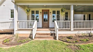 A two-story house with a front porch, a wooden door, and hanging plants. - 12 Mi to Tcu: Fort Worth Cottage w/ Farmland Views (Fort Worth)