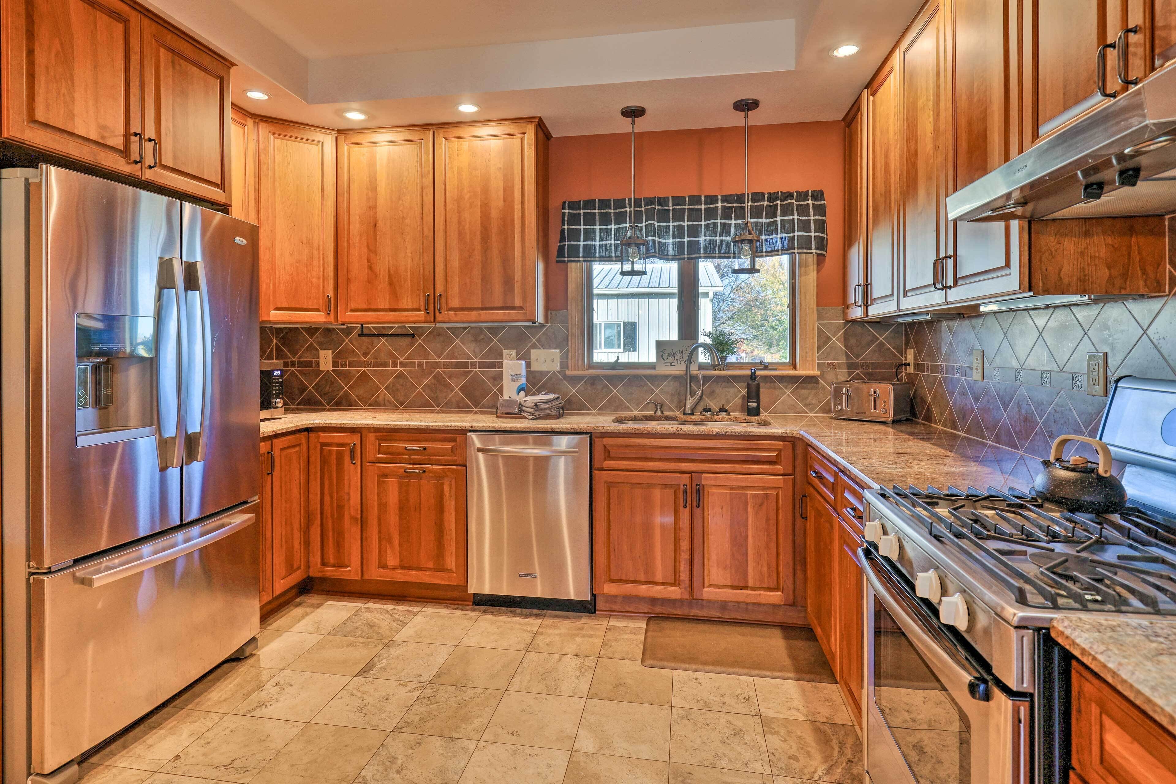 A modern kitchen with wooden cabinets, stainless steel appliances, and a tiled backsplash.