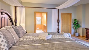 A neatly made bed with a patterned bedspread and pillows, a wooden headboard, and a potted plant in the corner. - Lakefront Romulus Retreat w/ Private Dock! (Romulus)