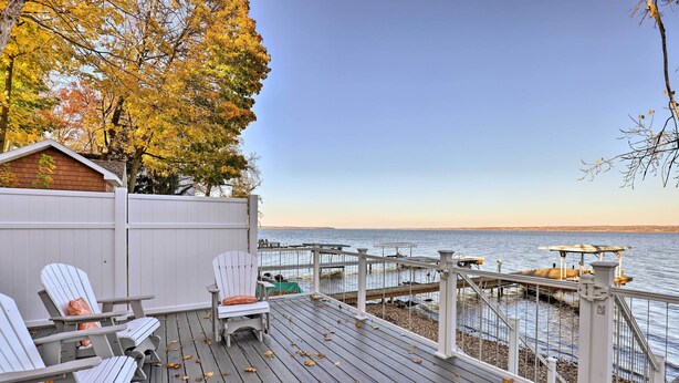 A wooden deck with Adirondack chairs, a small shed, and a view of a dock and water. - Lakefront Romulus Retreat w/ Private Dock! (Romulus)