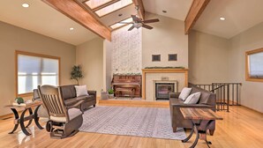 A spacious living room with a piano, a fireplace, and a high ceiling with skylights. - Lakefront Romulus Retreat w/ Private Dock! (Romulus)