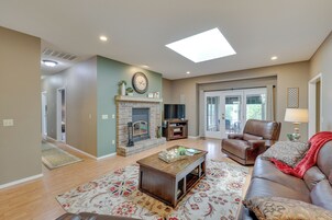 A living room with a fireplace, a sofa, a coffee table, and a TV.