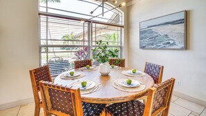 A dining area with a round table, wooden chairs, and a large window with blinds. - Spacious Oasis w/ Lagoon Pool & Spa in Cape Coral! (Cape Coral)