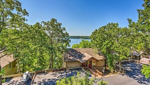 A lakeside cabin with a covered parking area, a small porch, and a view of the lake. - 1 Mi to Margaritaville! Cabin w/ Resort Perks (Osage Beach)
