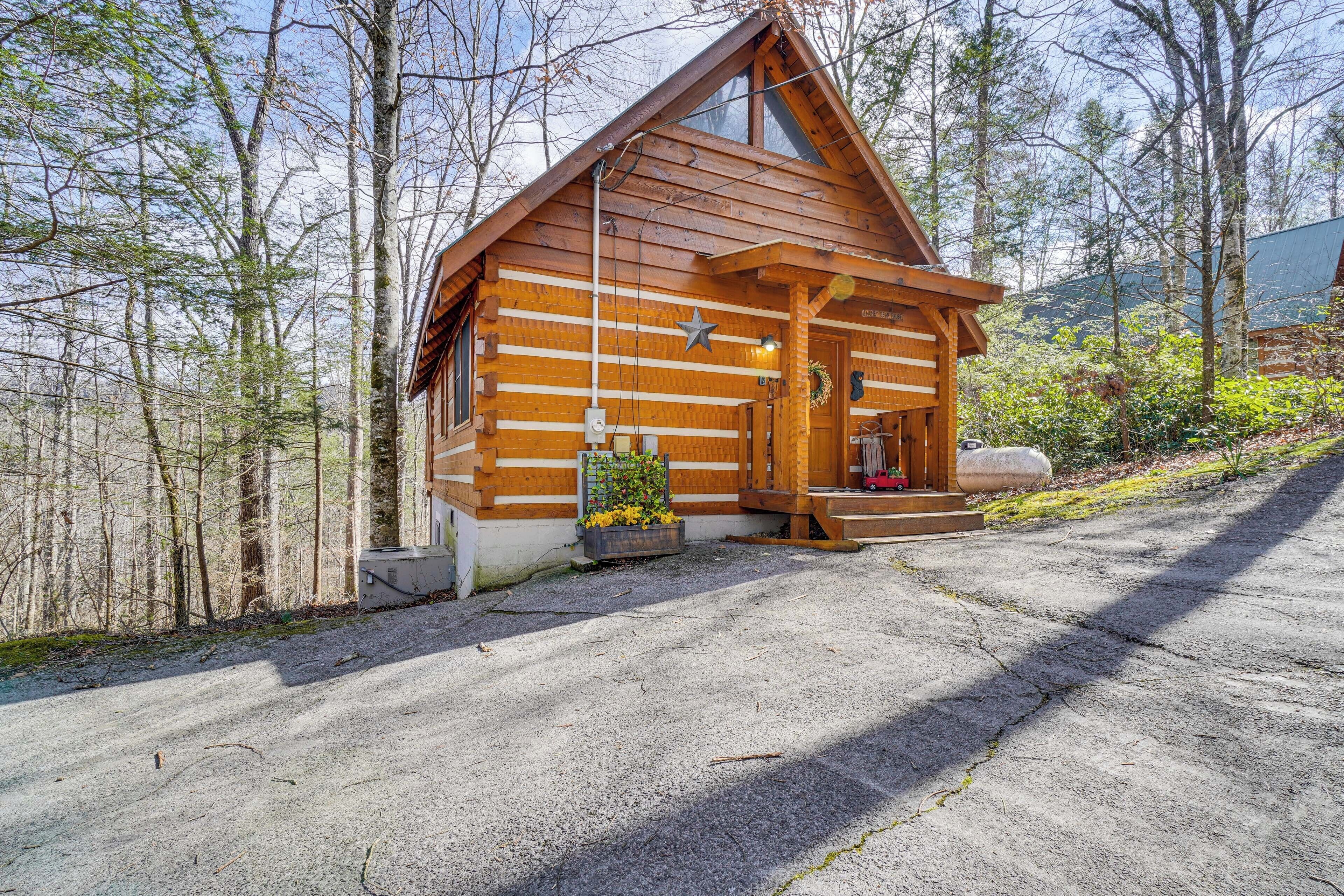 Eine Blockhütte mit Veranda, einem kleinen Garten und einem Schotterweg.