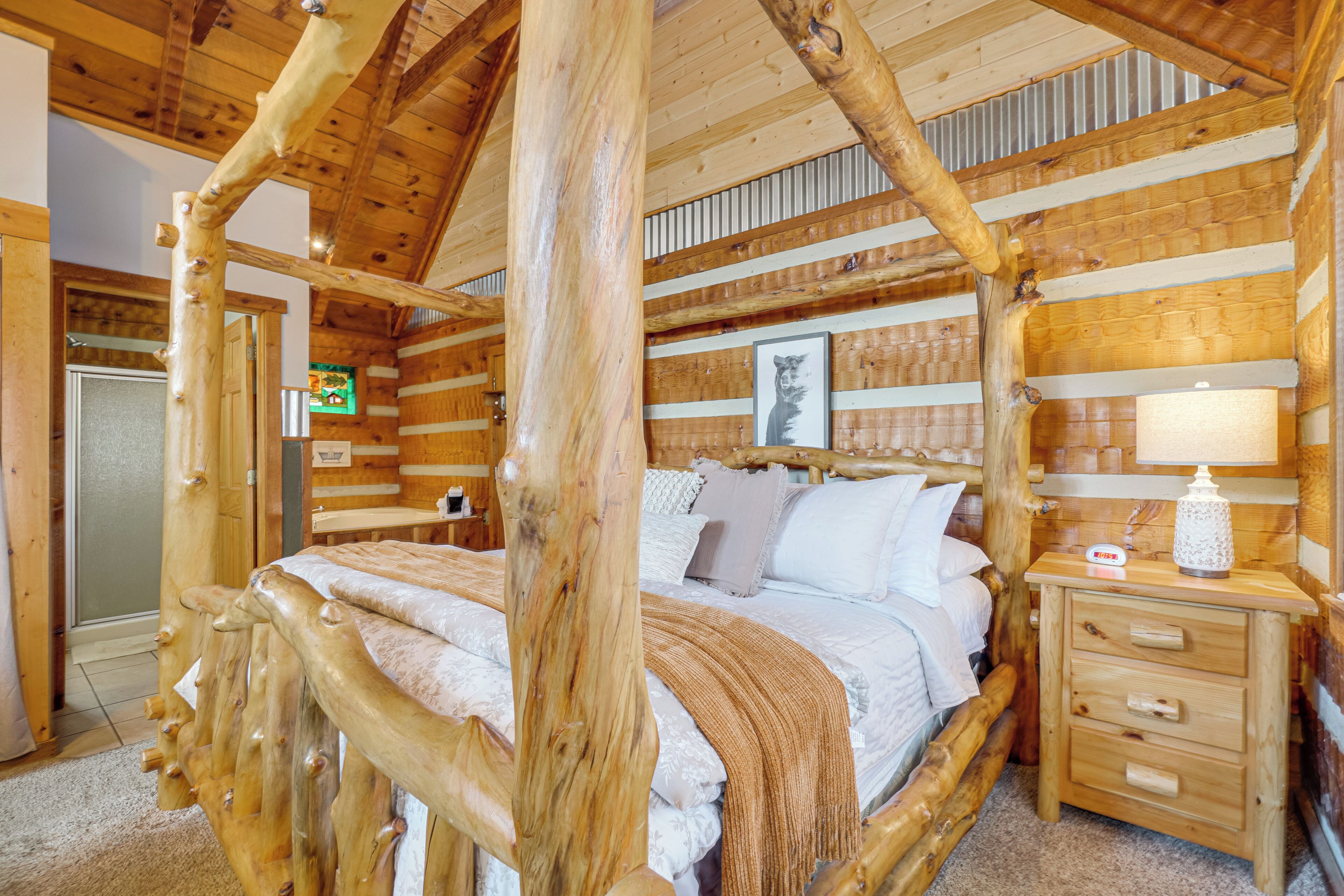 Una camera da letto in stile baita con un letto con struttura in legno, un comodino e un quadro appeso alla parete.