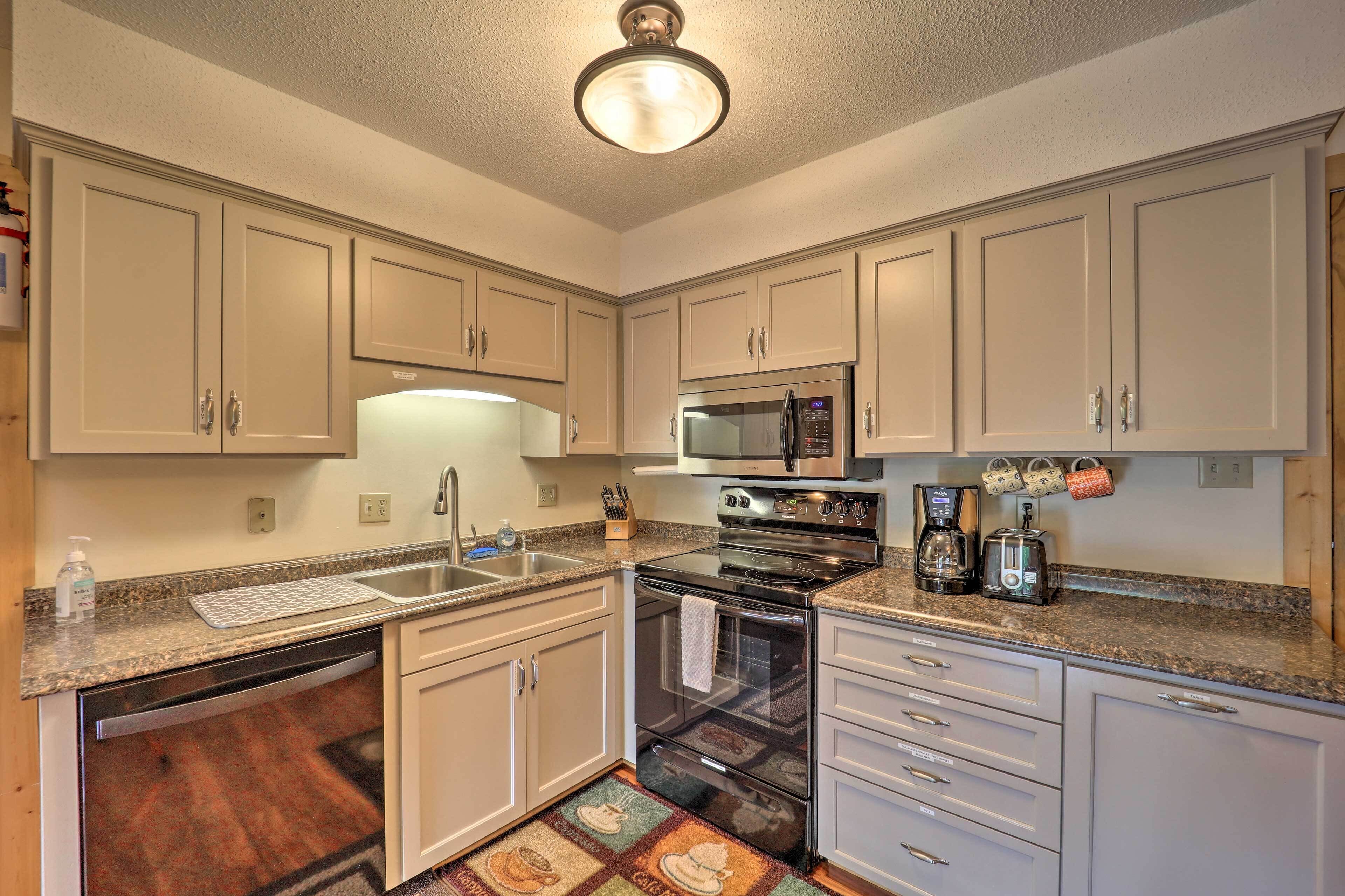 A kitchen with white cabinets, stainless steel appliances, and a granite countertop.