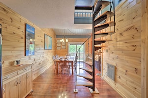 Un interior de madera con comedor, escalera y cocina.