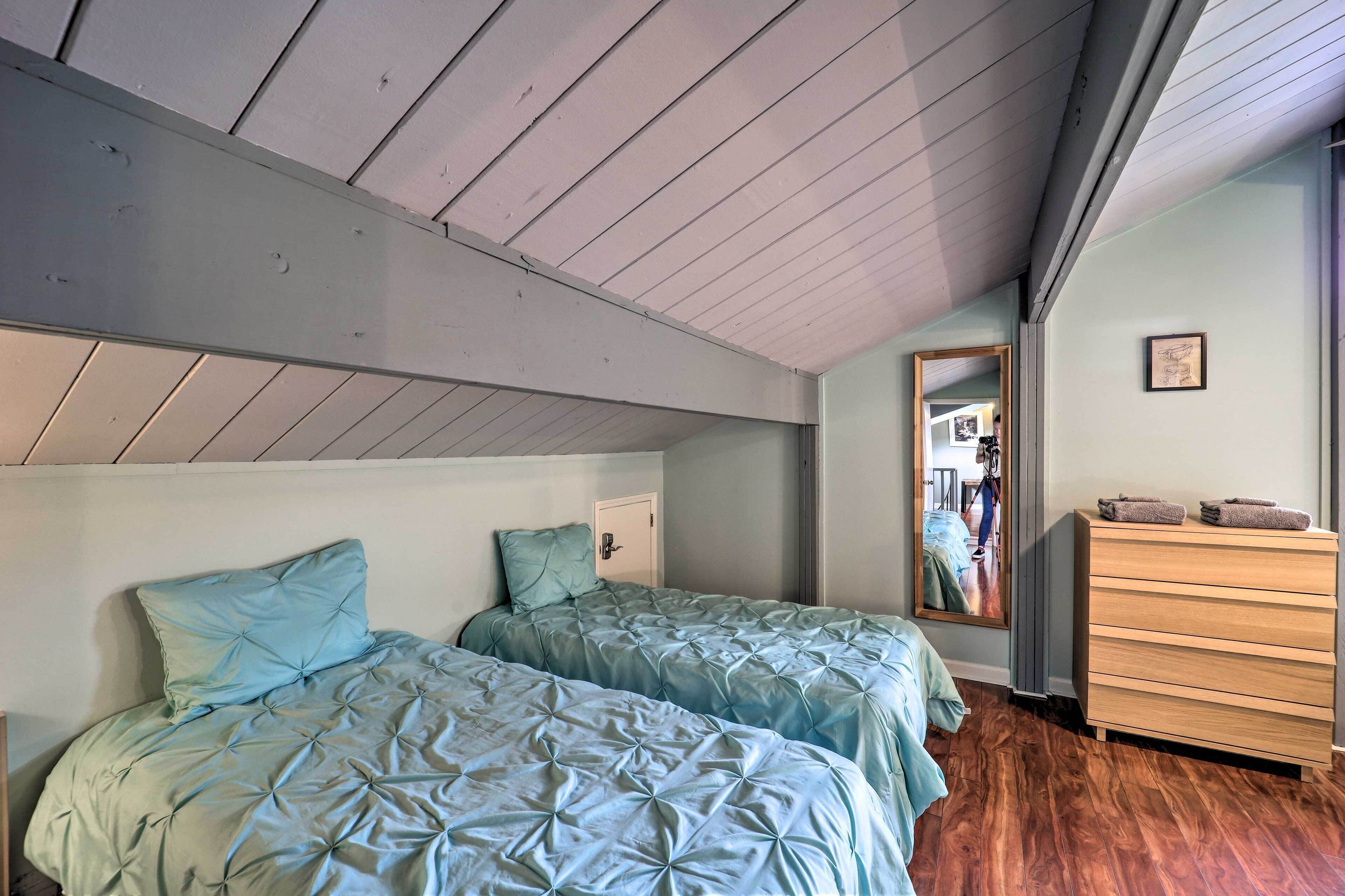 Un dormitorio con dos camas, un aparador y un espejo.