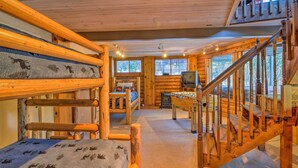A log cabin interior with bunk beds, a wooden staircase, a fireplace, and a television. - Cabin w/ Hot Tub: 3 Mi to Main St Breckenridge! (Breckenridge)