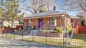 A single-story house with a brick facade, a purple front door, and a small porch with a railing. - Hot Tub + Walk to Midtown! Reno Retreat (Reno)