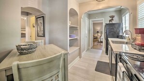 A modern kitchen with a central island, built-in shelving, and a refrigerator. - Hot Tub + Walk to Midtown! Reno Retreat (Reno)
