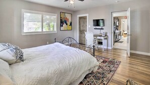 A bedroom with a bed, a ceiling fan, a desk, and a TV. - Hot Tub + Walk to Midtown! Reno Retreat (Reno)