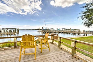 A wooden deck with two Adirondack chairs overlooking a water body with docks and boats. - Historic Swansboro Studio w/ Intracoastal View! (Swansboro)