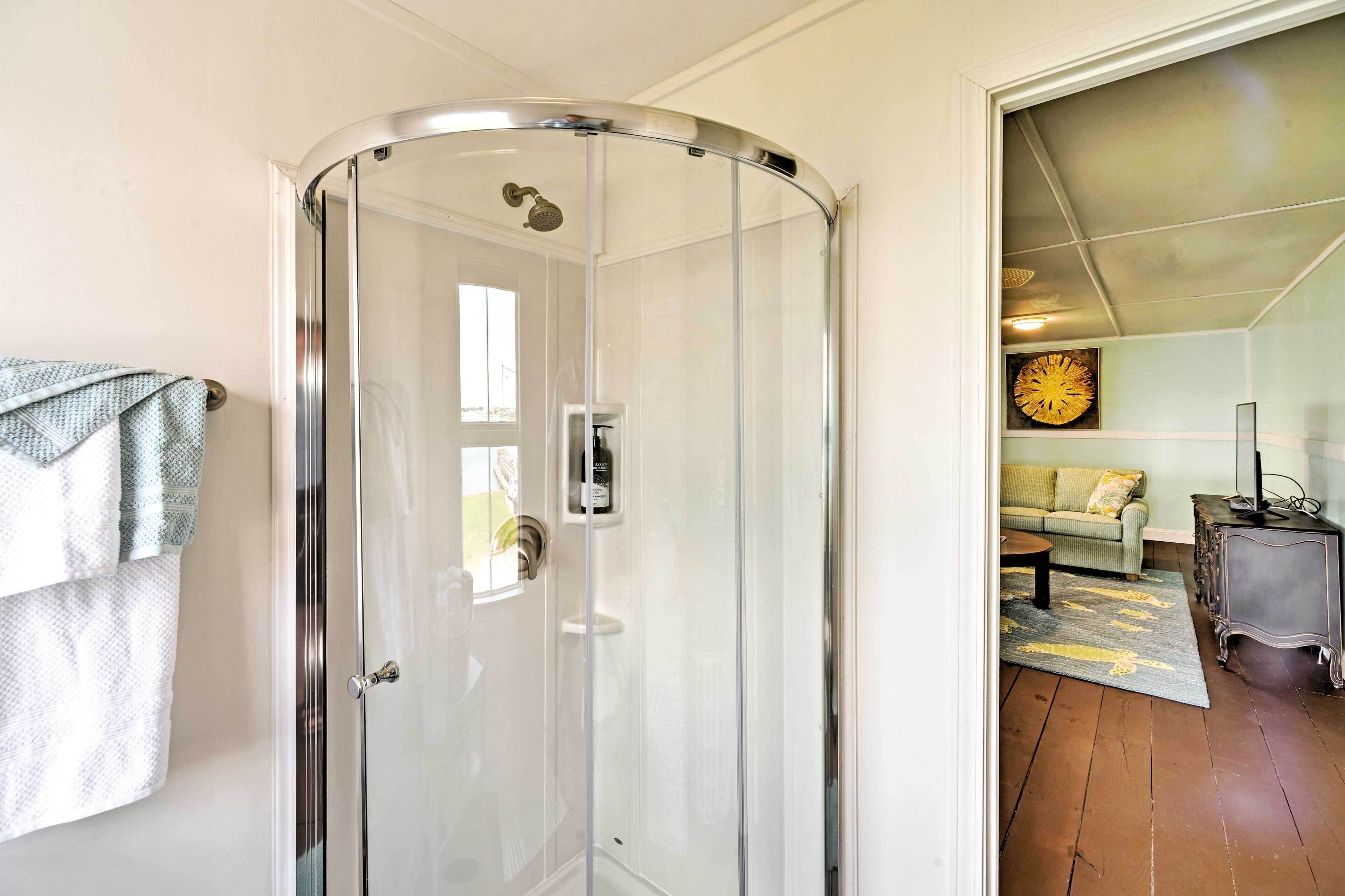 Une salle de bain moderne avec une douche à parois de verre, un porte-serviettes avec une serviette et des toilettes bien visibles.