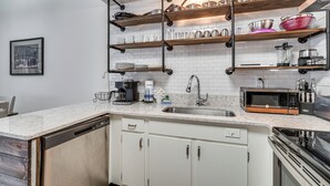 A kitchen with white cabinets, a stainless steel sink, a microwave, and a coffee maker. - Walkable Dtwn Gatlinburg Townhome w/ Pool Access! (Gatlinburg)