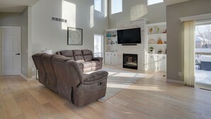 A spacious living room with a large brown leather sofa, a flat-screen TV, and a fireplace. - Cozy Eden Prairie Home < 21 Mi to Twin Cities (Eden Prairie)