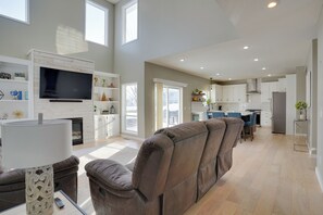 A spacious living area with a large sofa, a flat-screen TV, and a fireplace.