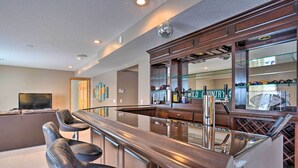 A bar area with a counter, stools, and a mirror. - Cozy Eden Prairie Home < 21 Mi to Twin Cities (Eden Prairie)