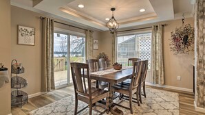 A dining room with a wooden table, chairs, a chandelier, and a fireplace. - Lakefront Home w/ Deck, Fishing Dock & Canoe! (Bridgeport)