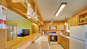 Una cocina moderna con armarios de madera, un microondas, un refrigerador y un lavamanos.
