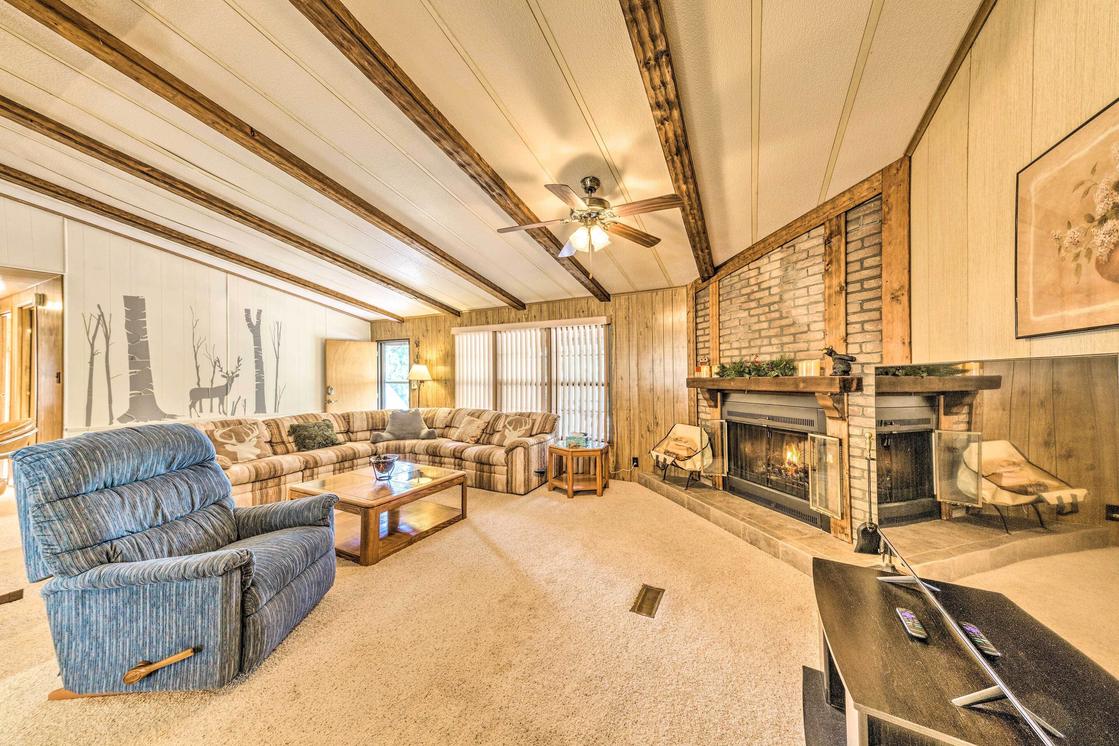 A cozy living room with a sectional sofa, a recliner, a coffee table, and a fireplace.