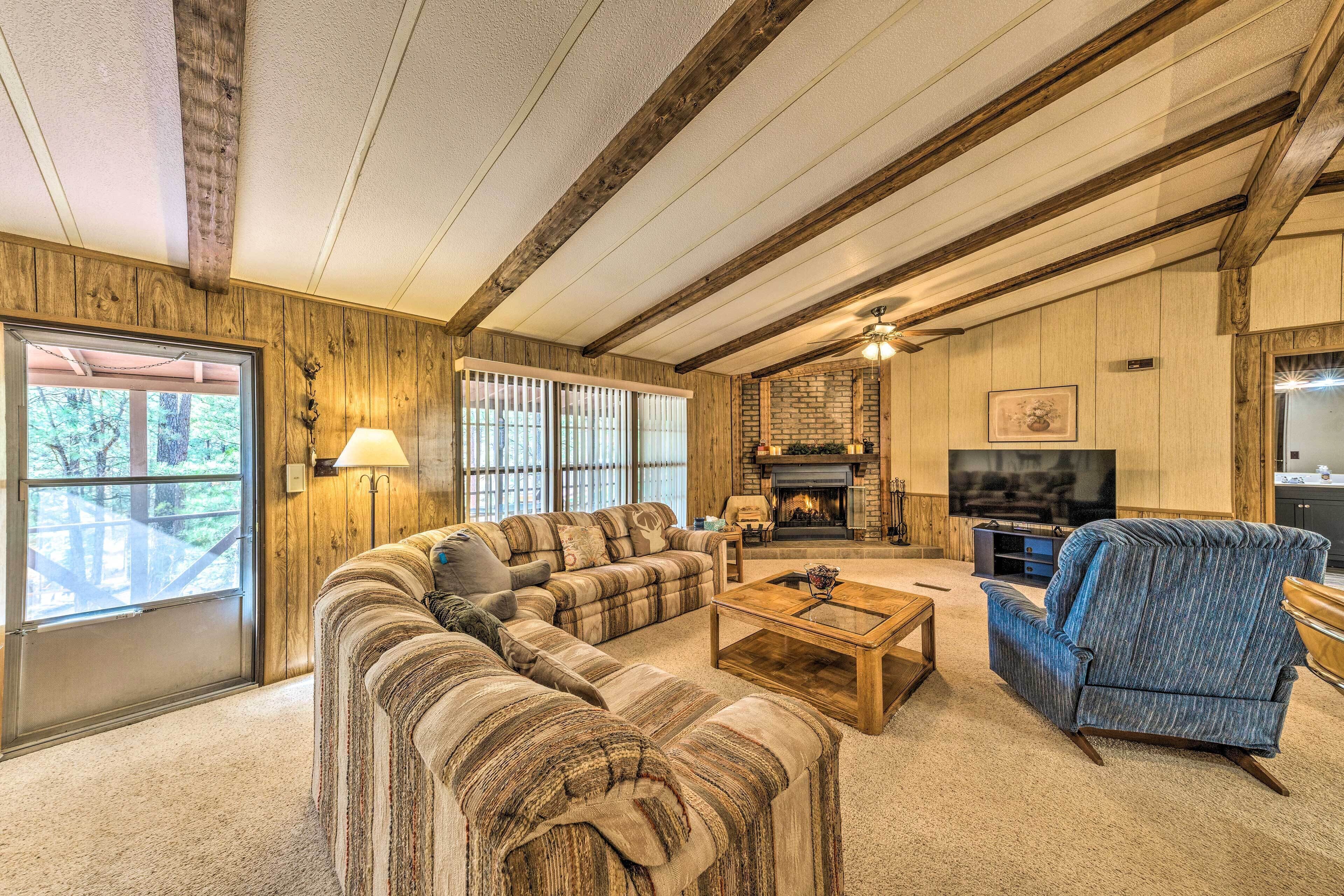 A cozy living room with a sectional sofa, a blue armchair, and a fireplace.