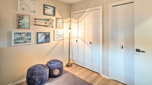 A hallway with a light floor lamp, a wall with framed pictures, and a set of white doors. - Waterfront Horseshoe Bay Retreat w/ Game Room! (Horseshoe Bay)