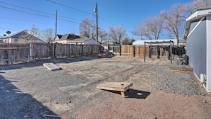 A backyard with a wooden deck, a shed, and a covered area. - Pet-friendly Home ~ 3 Mi to Downtown Pueblo! (Pueblo)