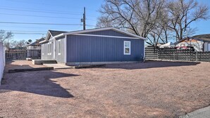 A small, single-story building with a dark blue exterior, a front door, and a small window. - Pet-friendly Home ~ 3 Mi to Downtown Pueblo! (Pueblo)