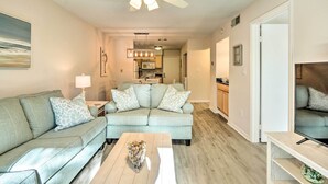 A living room with a light blue sofa, a coffee table, and a ceiling fan.