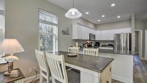 A modern kitchen with white cabinets, a central island, and stainless steel appliances. - Modern Escape in the Heart of Murrells Inlet (Murrells Inlet)
