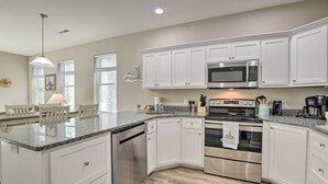A modern kitchen with white cabinets, stainless steel appliances, and a granite countertop. - Modern Escape in the Heart of Murrells Inlet (Murrells Inlet)