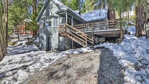 A cabin with a wooden staircase leading to a deck, surrounded by snow and trees. - California Retreat w/ Deck, Fire Pit & Grill! (Long Barn)