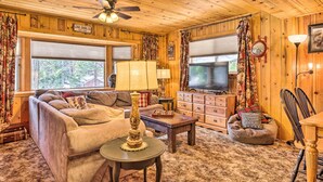A cozy cabin interior with a sofa, a coffee table, a television, and a fireplace. - California Retreat w/ Deck, Fire Pit & Grill! (Long Barn)