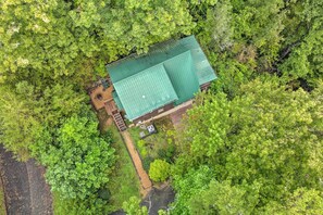 Eine Luftaufnahme eines Hauses mit einem grünen Dach, umgeben von üppiger Vegetation.