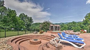 Gestalterter Außenbereich mit Feuerstelle, Lounge-Möbeln und einem Wasserfall.