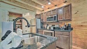 Eine moderne Küche mit Granit Arbeitsplatten, Edelstahlgeräten und Holzschränken.
