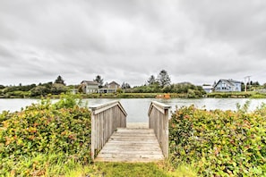 A wooden dock leading to a calm lake with houses in the background. - Walk to Beach: Ocean Shores House w/ Hot Tub (Ocean Shores)