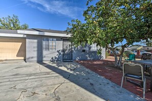 A residential property with a garage, a paved patio, and a tree providing shade. - Whittier Duplex Unit Near Beaches & Hiking! (Whittier)