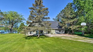 A house with a well-maintained lawn, a basketball hoop, and a large tree in front. - Lakefront Bellaire Getaway w/ Kayaks, Dock & Grill (Bellaire)