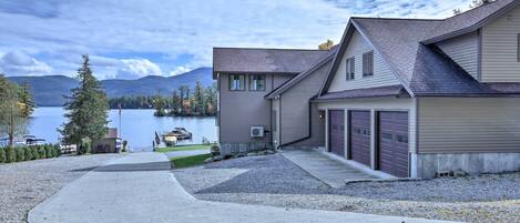 A two-story house with a garage, a driveway, and a lake view.