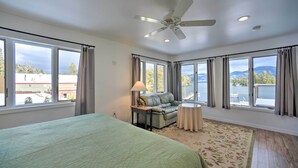 A hotel room with a large bed, a sofa, a small table, and a view of the outdoors. - Lake George Getaway w/ Mountain + Water Views (Bolton Landing)