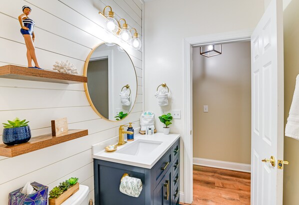 A bathroom with a vanity, a large mirror, and a light fixture above the mirror. - Tupelo Bay Golf Resort Condo - 1 Mile to Beach! (Murrells Inlet)