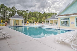 A swimming pool with lounge chairs and a lifeguard station. - Tupelo Bay Golf Resort Condo - 1 Mile to Beach! (Murrells Inlet)