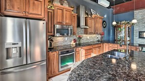 Una cocina moderna con electrodomésticos de acero inoxidable, armarios de madera y encimera de granito.