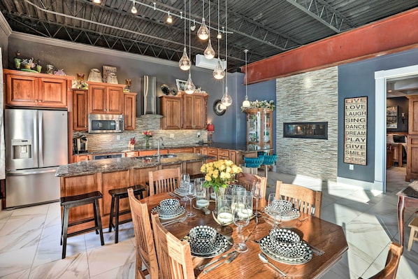 A modern kitchen with stainless steel appliances, wooden cabinets, and a central island with seating. - Regal River Retreat in the Heart of Yankton! (Yankton)