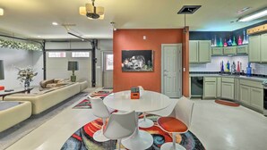 Une cuisine moderne avec des meubles de couleur vert clair, un plan de travail blanc et un tapis coloré.